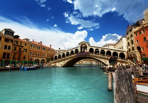 Visit the Rialto bridge in Venice.