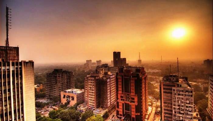 The tall concrete buildings of New Delhi during sunset