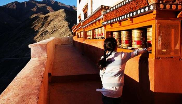 A little girl rotating the prayer wheel in Ladakh
