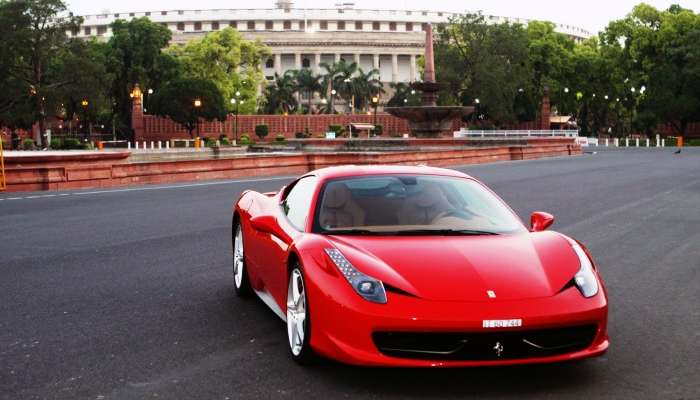 A red Ferrari on the wide roads of Delhi