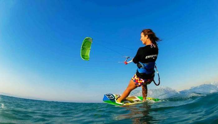 A free-spirited woman enjoys kiteboarding at Le Morne Beach Mauritius