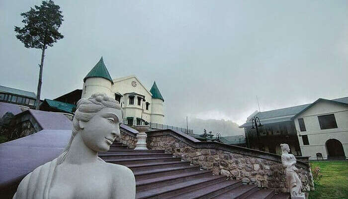 Striking statues and the atmospheric turrets of the Savoy on a misty day in Mussoorie