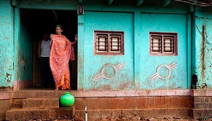 A woman looks outside her doorless house at Shani Shingnapur