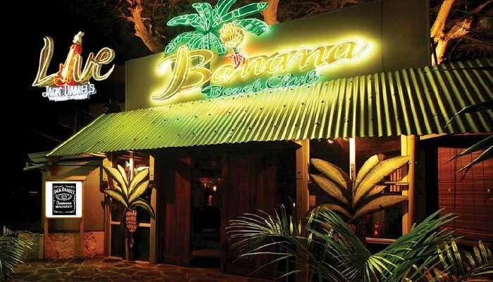 The glittering neon sign of Banana Beach Club attracts people to it