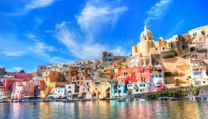 Boats lined up against the shore of the colorful city of Naples