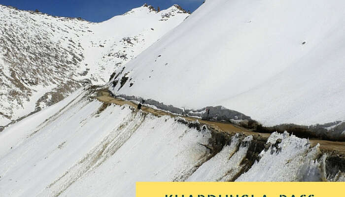 The narrow road amidst the snowclad mountains near Khardungla Pass that is the highest motorable road in the world