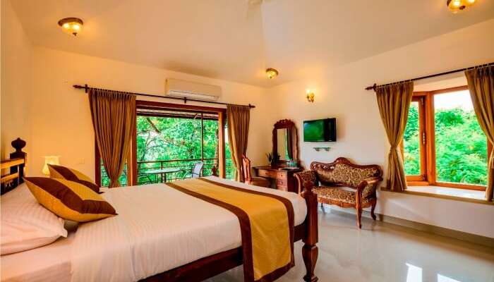 A bedroom with a garden view of Highland Heritage Goa
