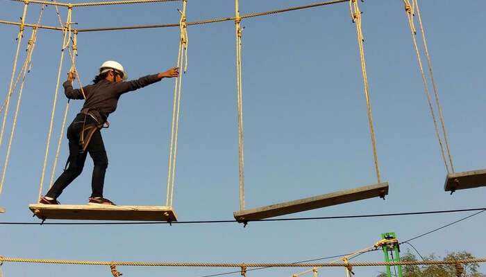 Adventurer performing plank walk at Rope Castle Adventure Park