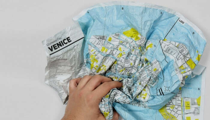 A crumbled waterproof map in a man’s hand