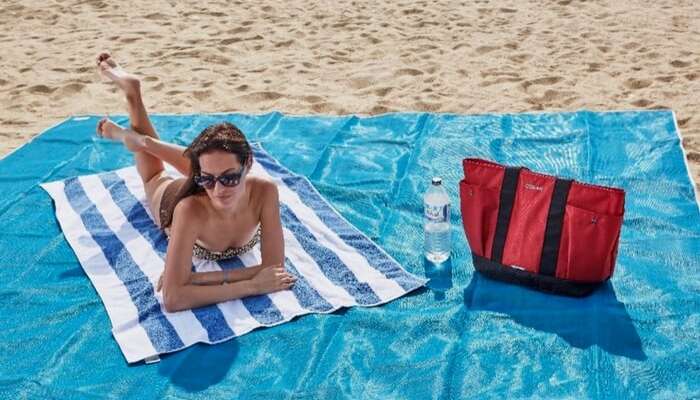 A woman sunbathing on a beach mat