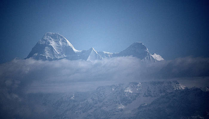 a snow covered mountain visible through floating mist