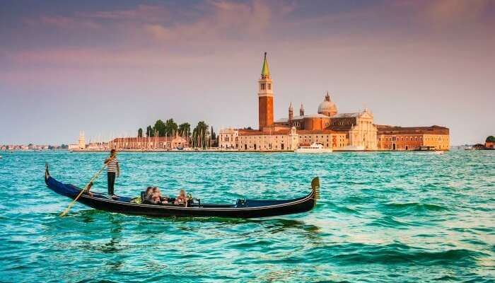 Panoramic view of traditional Gondola on Canal Grande with San Giorgio Maggiore church in the background