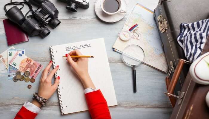 Top view of a woman writing travel plans