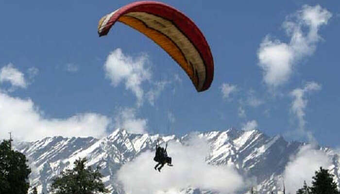 A traveler paragliding in Solang Valley in Manali