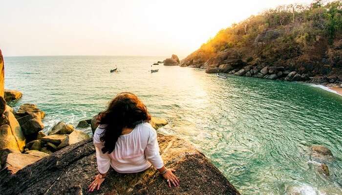 A traveler enjoying a sunset at the Butterfly beach in Goa