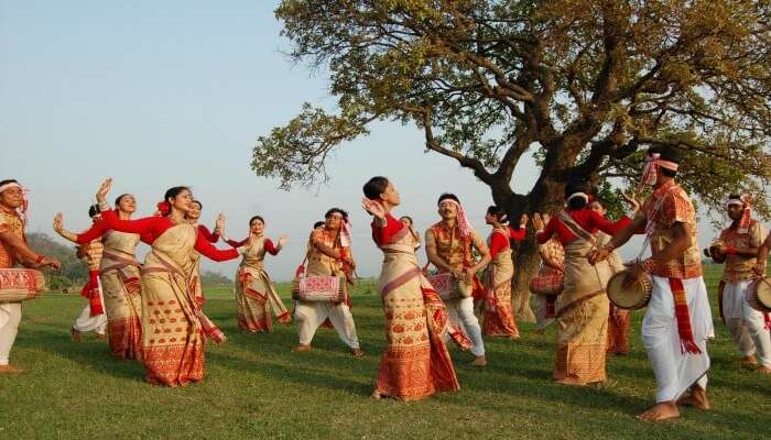 Assamese women and men dancing during Bihu