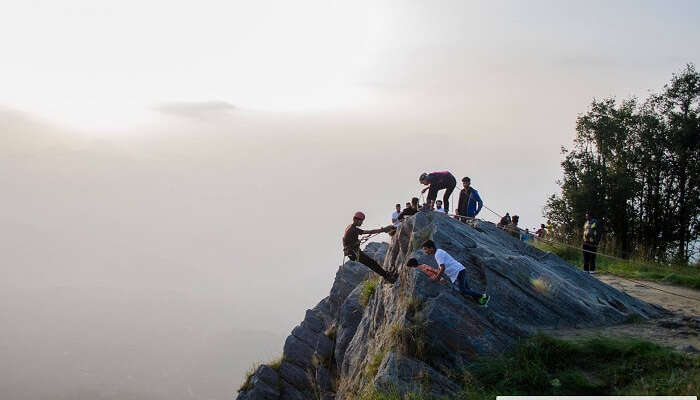 A bunch of travelers trying rock climbing on one of the weekend trips from Delhi to Mukteshwar