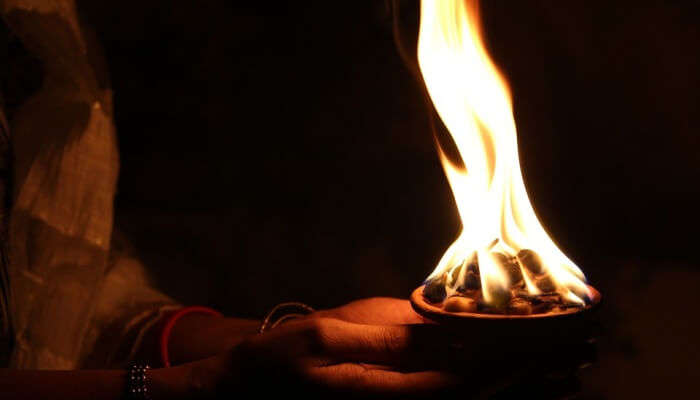 woman's hands holding a diya