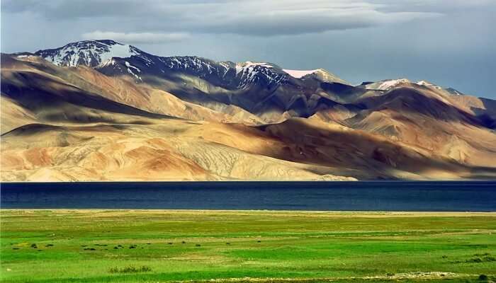 view of grass, lake, and mountains