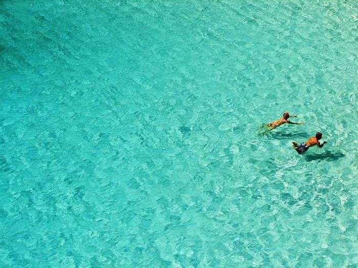 Swimmers in the turquoise Sea of Cala Macarelleta