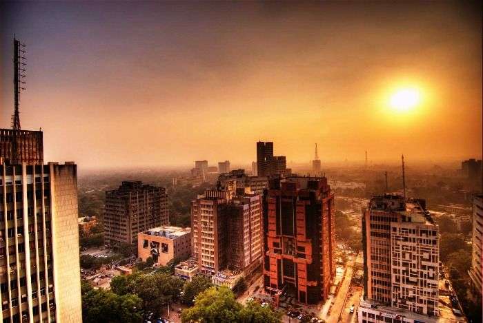 The tall concrete buildings of New Delhi during sunset