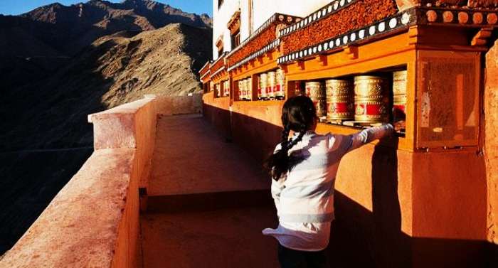 A little girl rotating the prayer wheel in Ladakh