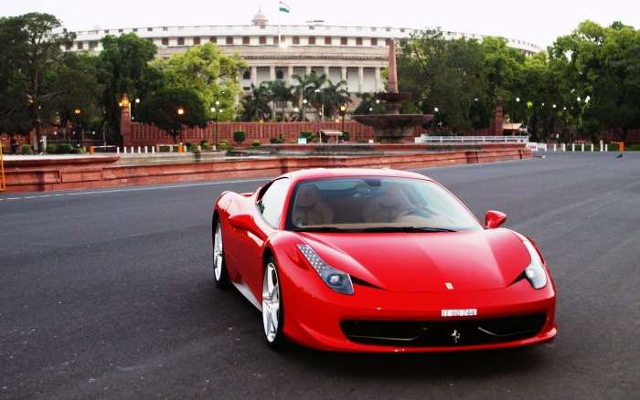 A red Ferrari on the wide roads of Delhi