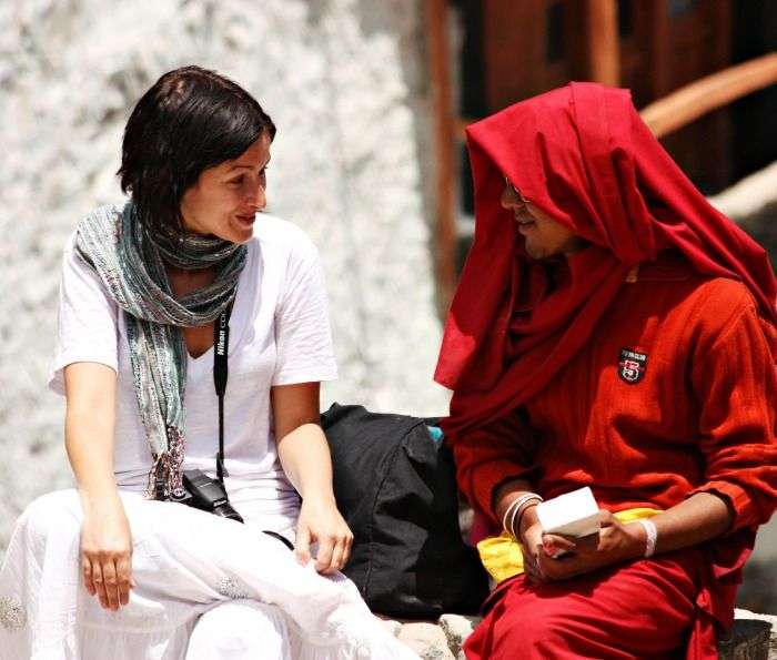 A tourist chatting with a monk at a monastery in Ladakh