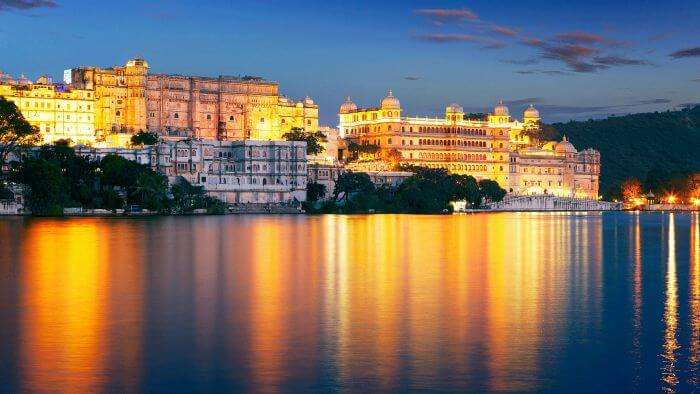 The reflection in the Pichola Lake of the well-lit Udaipur at night