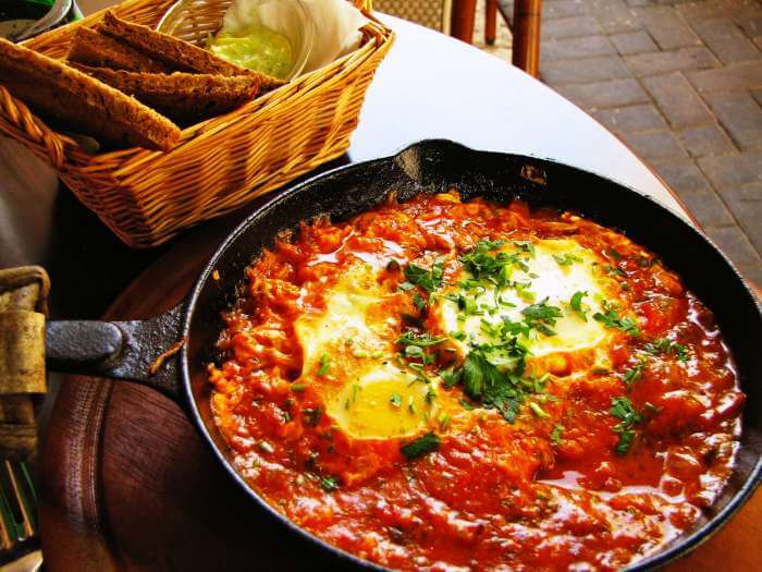 Shakshuka served with garlic bread and mint sauce.
