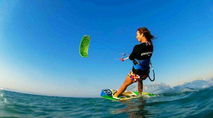 A free-spirited woman enjoys kiteboarding at Le Morne Beach Mauritius
