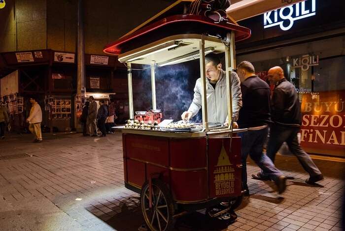 A common street food vendor cooks the local delicacies on a portable food cart