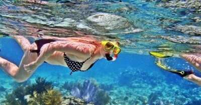a girl snorkeling in water