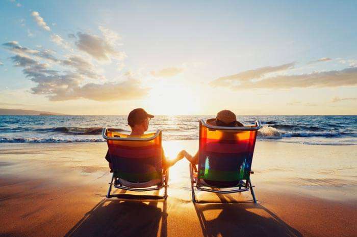 A couple enjoying the sunset on their beach honeymoon