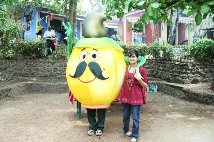 A tourist posing with the mascot of Cashew and Coconut festival in Goa