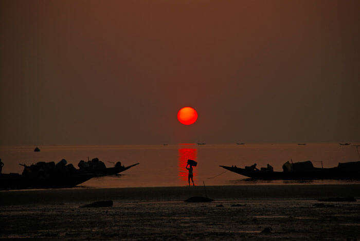 Sun sets on Bay of Bengal at Frasergunj as fishermen return home from the sea
