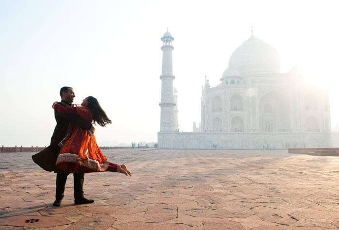 A couple enjoying a romantic moment with Taj Mahal in the backdrop