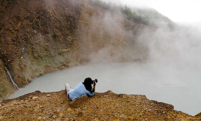 A young lady takes a snap at the boiling lake of Dominica