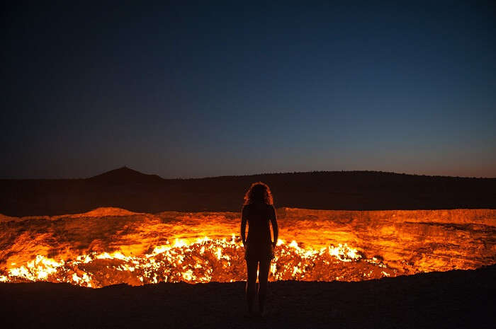 A woman stands at the edge of the door to hell in Turkmenistan