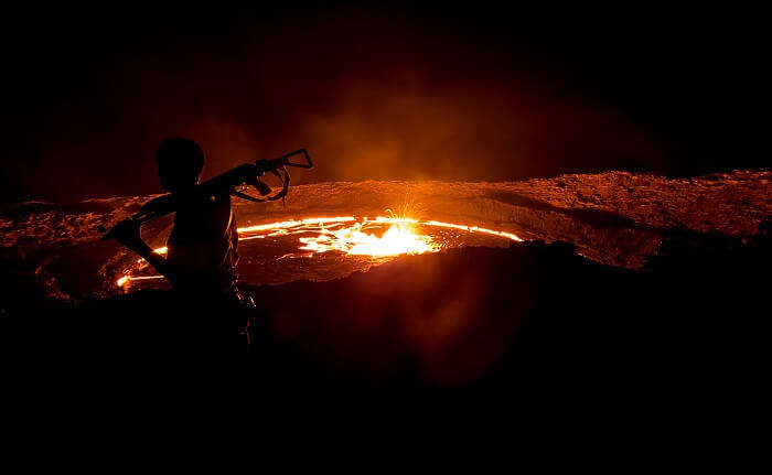 A man at night takes guard at the Erta Ale Volcano
