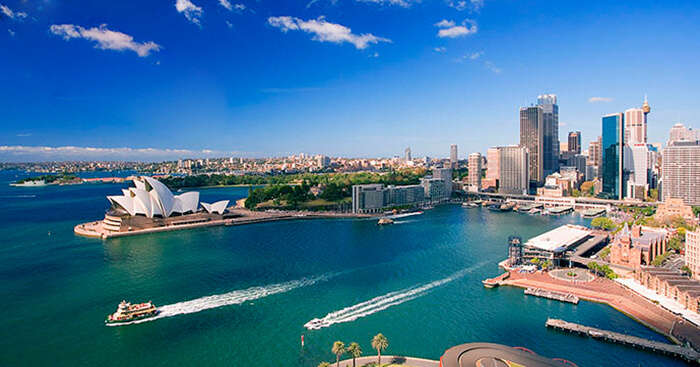 An aerial shot of a cruise passing by the Sydney Opera House in Australia