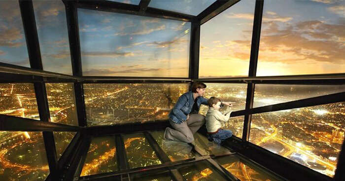 Mother and child enjoy views of the city of Melbourne from a glass deck