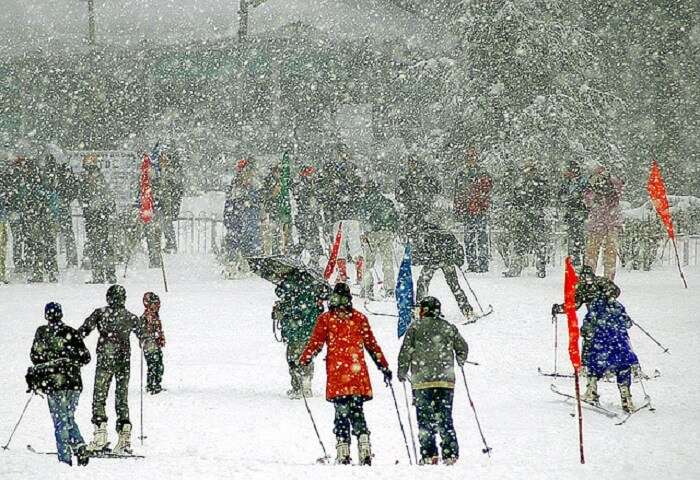 Tourists skiing under snowfall in Patnitop