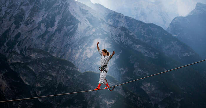 A woman highlining at theInternational Highline Meeting in Monte Piana