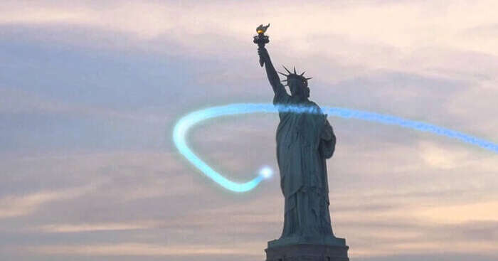 A jetpack flyer flies past the Statue of Liberty