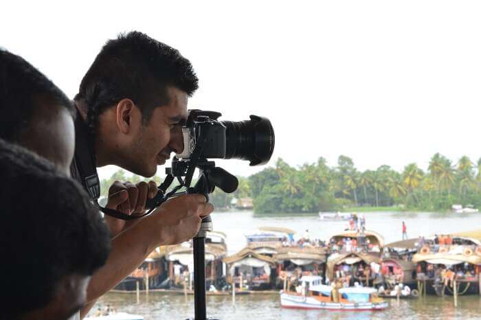 A photographer takes a photo during snake boat race practice session