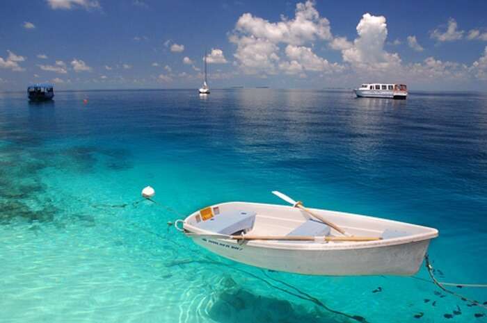 A boat parked in the turquoise waters near the Fihalhohi Island