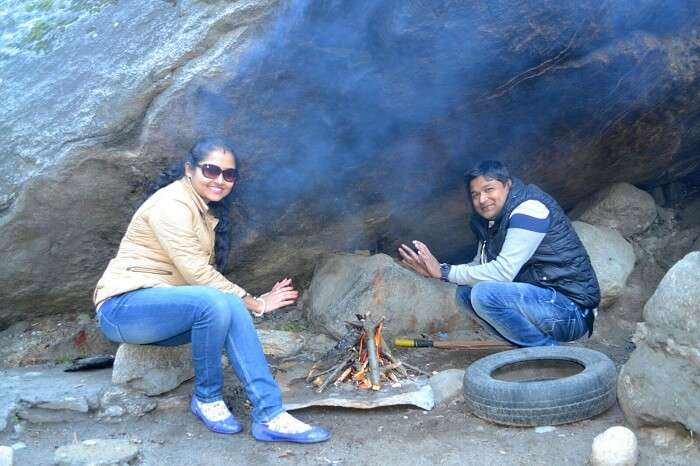 Madhumita and her husband near a bonfire in Manali