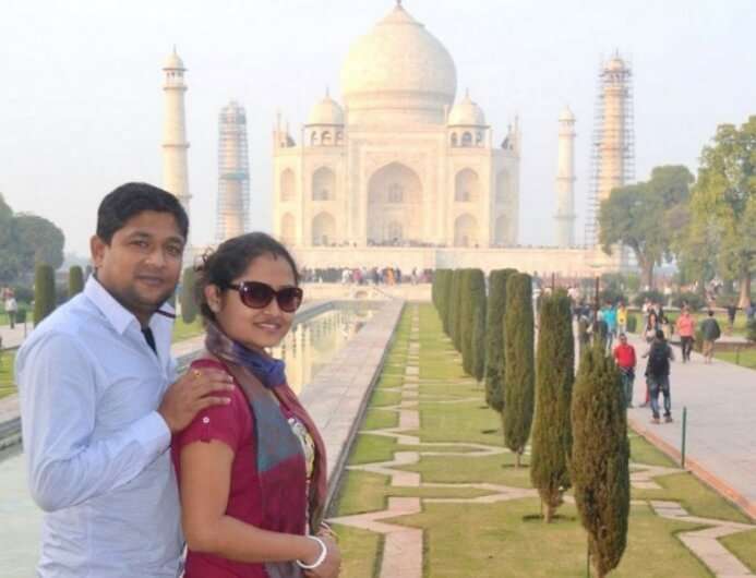 Madhumita and her husband pose in the background of Taj Mahal