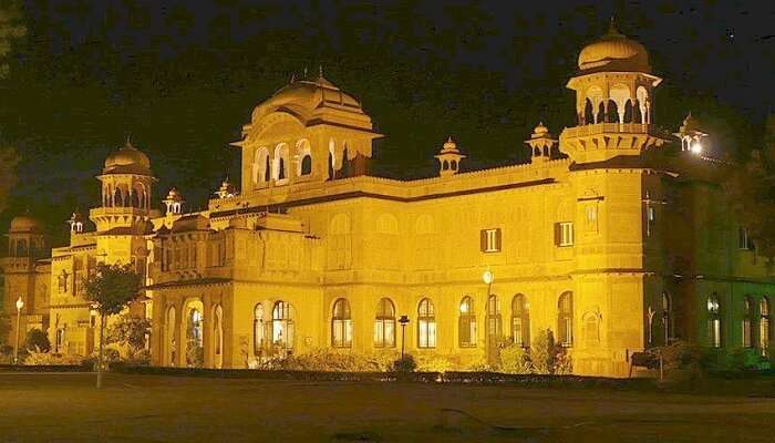 A well-lit entrance of the Lalgarh Palace at night